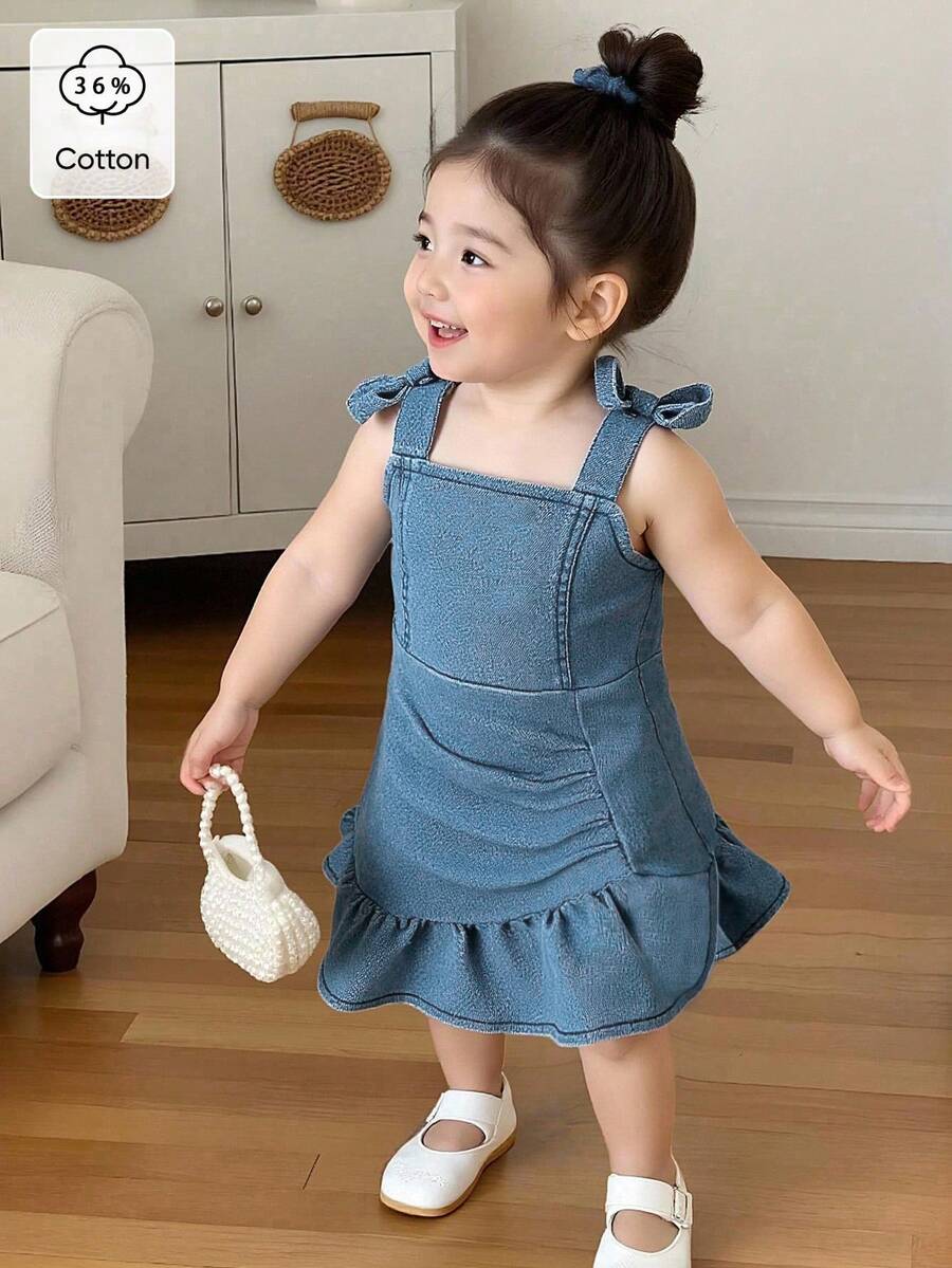 SHEIN Rochie din denim pentru bebeluși, vară ușoară, model nou, albastru spălare medie, design drăguț și dulce, streetwear, decor adorabil cu fundă și bretele, talie încrețită, tiv cu volane, tiv tip sirenă, material elastic din denim din bumbac, potrivită pentru purtare zilnică, întâlniri, școală, naveta, colecția nouă de vară 2026 - Spălare medie - Vizualizare 1