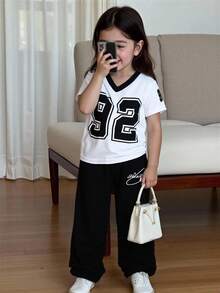 SHEIN Bộ đồ thể thao thường ngày 2 món cho bé gái sơ sinh và trẻ nhỏ, gồm áo thun ngắn tay cổ chữ V màu đỏ tía in số phối trắng và quần dài in hoa màu xám, thích hợp mặc hàng ngày, xem thể thao và phong cách đường phố. - màu đen - Xem 1