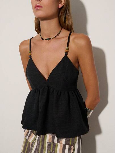 Nöista 黑色吊带背心，深V领设计，高腰收腰，饰有串珠肩带。优雅百搭，是夏夜、派对、度假或日常精致造型的完美之选。