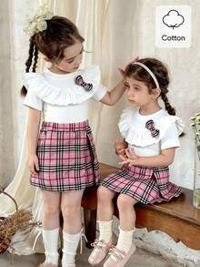 SHEIN Elladie kids 两件套女童休闲新款T恤套装，正面可爱粉色格子图案3D蝴蝶结设计，白色罗纹针织荷叶边T恤，搭配粉色格子开衩短裙，适合可爱、俏皮、休闲、舒适的日常穿着，也适合上学、郊游、海滩、派对等场合。春夏两件套儿童套装，格子裙，女童夏季格子裙，幼儿女童可爱复古风蝴蝶结套装，女童服装裙装套装 - 彩色 - 查看 12