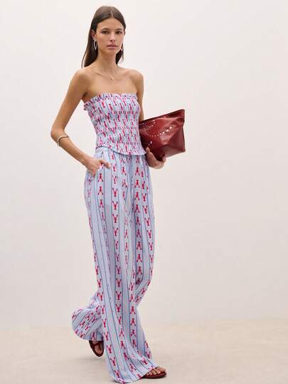 Nöista Bộ đồ hai mảnh xếp ly với họa tiết vui nhộn khắp thân áo. Áo quây co giãn mang lại sự vừa vặn và thoải mái, trong khi quần ống rộng cùng màu rủ xuống nhẹ nhàng. Hoàn hảo cho kỳ nghỉ, những ngày đi biển và các hoạt động mùa hè, cũng như cho mùa xuân và các dịp lễ hội.