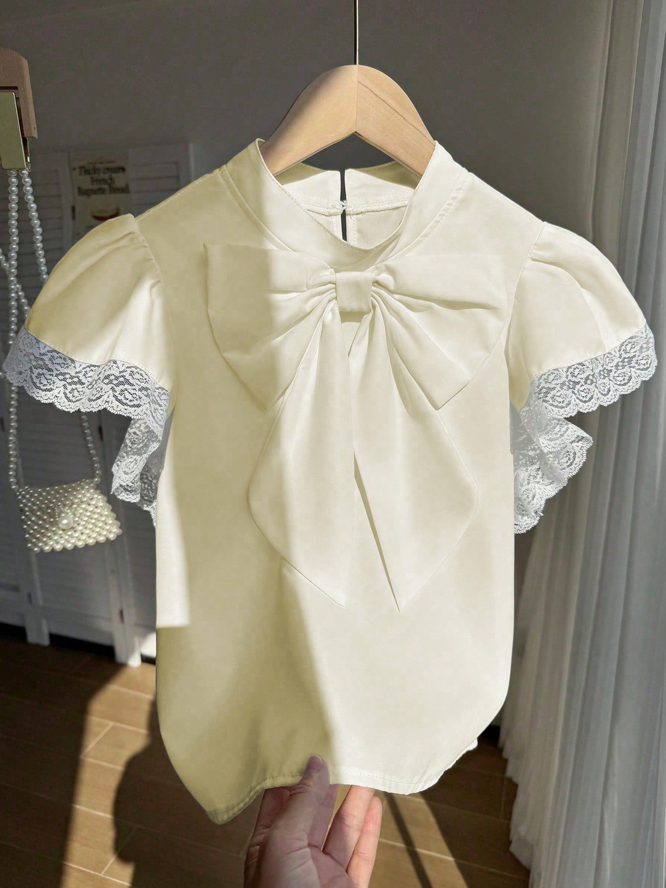 بلوزة أنيقة بأكمام واسعة وربطة عنق كبيرة من الدانت...