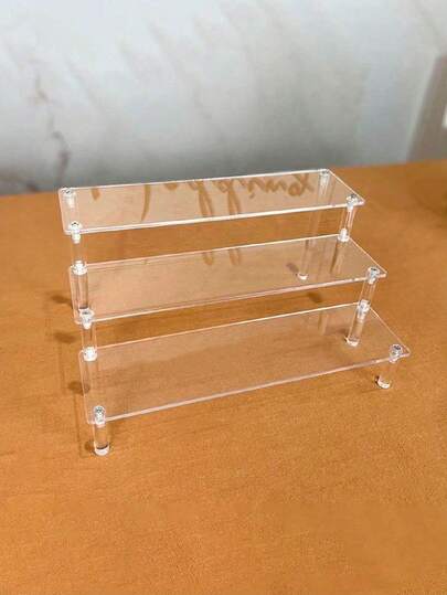 Một kệ đựng đồ hình thang bằng acrylic trong suốt, kệ để bàn đa năng bằng acrylic trong suốt dùng để đựng búp bê tay, nước hoa, mỹ phẩm và phụ kiện.
