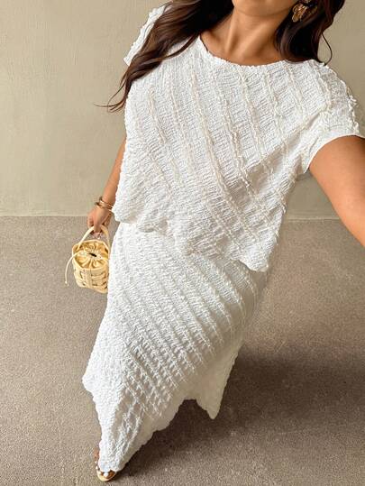 Auralis Conjunto básico folgado em tecido canelado elástico, composto por blusa de manga curta com ombros caídos e saia evasê folgada. Tamanhos grandes. Ideal para ocasiões casuais.