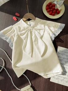 بلوزة أنيقة بأكمام واسعة وربطة عنق كبيرة من الدانت...