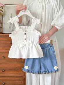 SHEIN Vintaside Kids Bộ đồ hai mảnh Younggirl gồm áo yếm màu vàng và quần short denim cạp cao có túi, thích hợp cho mùa xuân và hè, ngọt ngào, dễ thương và đa năng. Chất vải dệt có độ dày vừa phải, được trang trí bằng nơ xếp ly và họa tiết hoa 3D. Cúc áo in họa tiết da báo tạo thêm nét cổ điển. Bộ đồ này phù hợp cho đi học hàng ngày, tham quan các địa điểm nổi tiếng, du lịch, thư giãn tại nhà và dự tiệc. - Nhiều màu - Xem 3