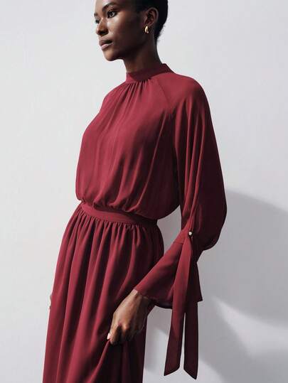 Aveloria Modichic 酒红色雪纺连衣裙，高领褶皱设计，长袖系带袖口，松紧腰身，飘逸裙摆，轻盈面料，柔软顺滑的质感，优雅复古风格，修身宽松版型，适合正式宴会、晚宴、婚礼宾客、商务聚会等场合，展现女性优雅高贵的气质，是春秋季的理想之选。