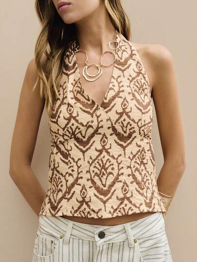 Nöista 这款露背吊带上衣采用可调节松紧带设计，胸下有缝线，饰以复古棕色调印花。非常适合春夏穿着，是度假或参加音乐节的理想之选。
