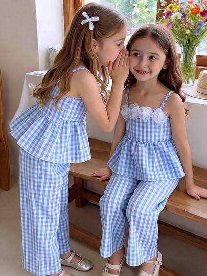 SHEIN Vintaside Kids Young Girls' Fresh Floral Gingham Print Camisole And Wide Leg Pants Set. Soft And Skin-Friendly Fabric, Comfortable To Wear. The Camisole Features A Sweet Princess-Like 3D Organza Flower Decoration On The Chest, And The Waist Is Elasticated For A Close Fit. The Wide-Leg Pants In The Same Gingham Print Have A Relaxed Silhouette For Unrestricted Movement. The Overall Style Is Fresh And Playful, Suitable For Daily Outings, Park Play, And Family Gatherings. The Lightweight Fabric Makes It An Ideal Choice For Spring And Summer Seasons.