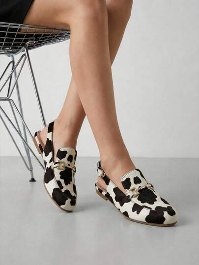 Mocasines destalonados de mujer disponibles en diferentes colores, diseño elegante con acabado liso, estructura clásica tipo mule con correa trasera ajustable, adorno metálico dorado en el empeine, horma estilizada de punta almendrada, interior suave y forro confortable, suela ligera y flexible con excelente tracción, perfectos para combinar con jean, falda, pantalón de vestir o vestido, ideales para diario o eventos especiales, realza cualquier atuendo y aporta sofisticación atemporal