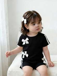 SHEIN Baby Girls' Chic 2-Piece Black Outfit Set, Short Sleeve Crew Neck Top With White Bow Accents & Side Stripe Details, Matching Elastic Waist Shorts With Bows, Ultra-Soft Lightweight Breathable Fabric, Sweet Sporty Casual Style For Everyday Wear, Playdates & Outdoor Activitie - Black - View 8
