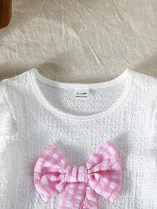 SHEIN Bộ đồ cho bé gái gồm áo dệt kim jacquard màu trắng cổ tròn tay ngắn thắt nơ và chân váy kẻ caro màu hồng. - Hồng - Xem 4