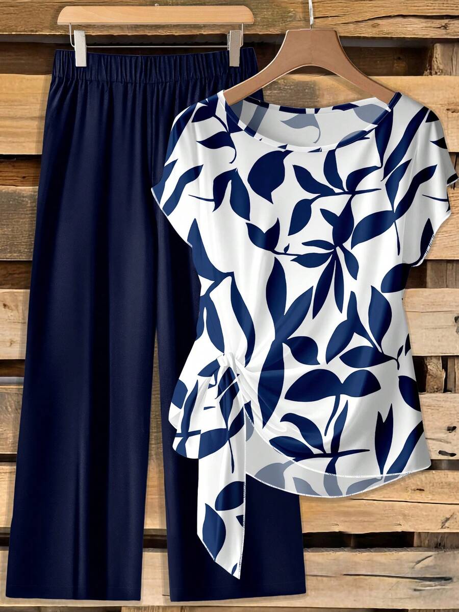 SHEIN Clasi Phong cách cổ điển giản dị, thanh lịch, đa năng, màu trắng ấm áp, nền họa tiết hoa xanh dương, phù hợp cho mùa thu/đông. Bộ 2 món gồm áo sơ mi cổ tròn tay ngắn dáng rộng, thắt nơ và quần ống đứng dáng rộng cho nữ, thoải mái và ấm áp, thích hợp cho công sở. - Nhiều màu - Xem 1