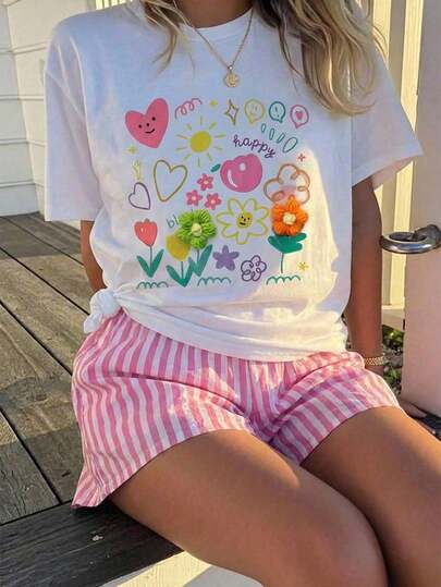 这套少女套装包含一件白色T恤和一条粉白条纹短裤。T恤上印有色彩鲜艳的涂鸦风格图案，包括太阳、花朵、爱心、对话框以及“快乐”和“空白”字样。部分花朵图案采用3D刺绣工艺，增添了立体感和俏皮感。整体风格活泼可爱，充满青春活力，适合日常休闲、上学或居家穿着。是春夏少女的理想之选。
