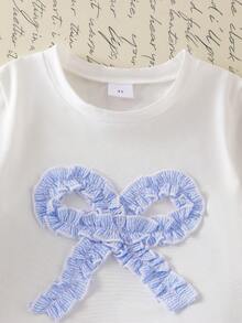 SHEIN Genkimix Kids Outfit estivo casual e carino per bambine e ragazze: top bianco a maniche corte con ricamo a fiocco, pantaloncini di jeans blu con tasche e ricami - Bianco - Visualizzare 7