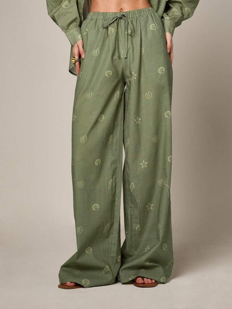 Calças de perna larga com toque de linho e estampa náutica bordada em dourado.