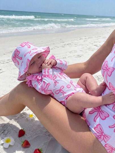 SHEIN Traje de baño para bebé recién nacido, lindo y modesto, de un solo pieza con estampado de lazo rosa, manga larga y volante en los hombros, parte inferior triangular de manga larga, moda casual elegante, adecuado para nadar, vacaciones de verano, playa, piscina, fiesta