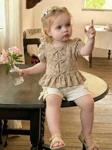 SHEIN Vintaside Kids 女婴衬衫，采用独特的印花面料，乡村度假风格，可爱时尚，适合春夏穿着，带有蝴蝶结装饰。 - 杏色 - 查看 1