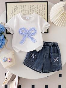 SHEIN Genkimix Kids Outfit estivo casual e carino per bambine e ragazze: top bianco a maniche corte con ricamo a fiocco, pantaloncini di jeans blu con tasche e ricami - Bianco - Visualizzare 5