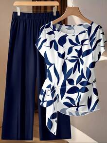 SHEIN Clasi Phong cách cổ điển giản dị, thanh lịch, đa năng, màu trắng ấm áp, nền họa tiết hoa xanh dương, phù hợp cho mùa thu/đông. Bộ 2 món gồm áo sơ mi cổ tròn tay ngắn dáng rộng, thắt nơ và quần ống đứng dáng rộng cho nữ, thoải mái và ấm áp, thích hợp cho công sở. - Nhiều màu - Xem 3