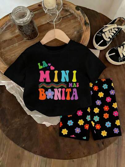 Conjunto informal de niña pequeña con parte superior de manga corta con estampado gráfico lindo y dulce, y shorts con estampado floral. Conjunto de ropa para niñas, adecuado para primavera/verano, salidas, fotografía, vacaciones, días festivos, regalos