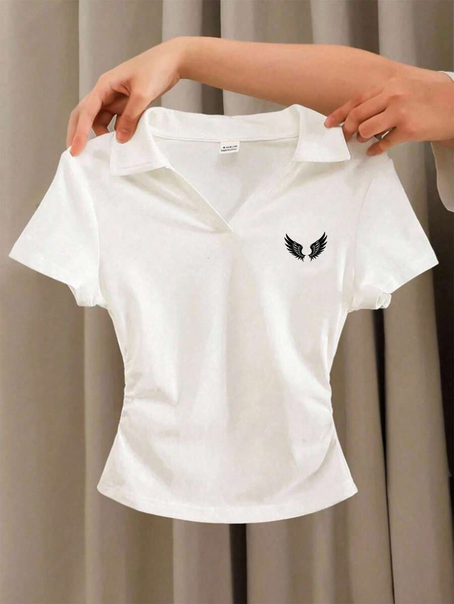 Áo thun polo tay ngắn dáng lửng màu trơn dành cho bé gái tuổi teen, cổ chữ V, ôm sát, có bèo nhún bên hông, in logo cánh thiên thần cổ điển tinh tế. - trắng - Xem 1