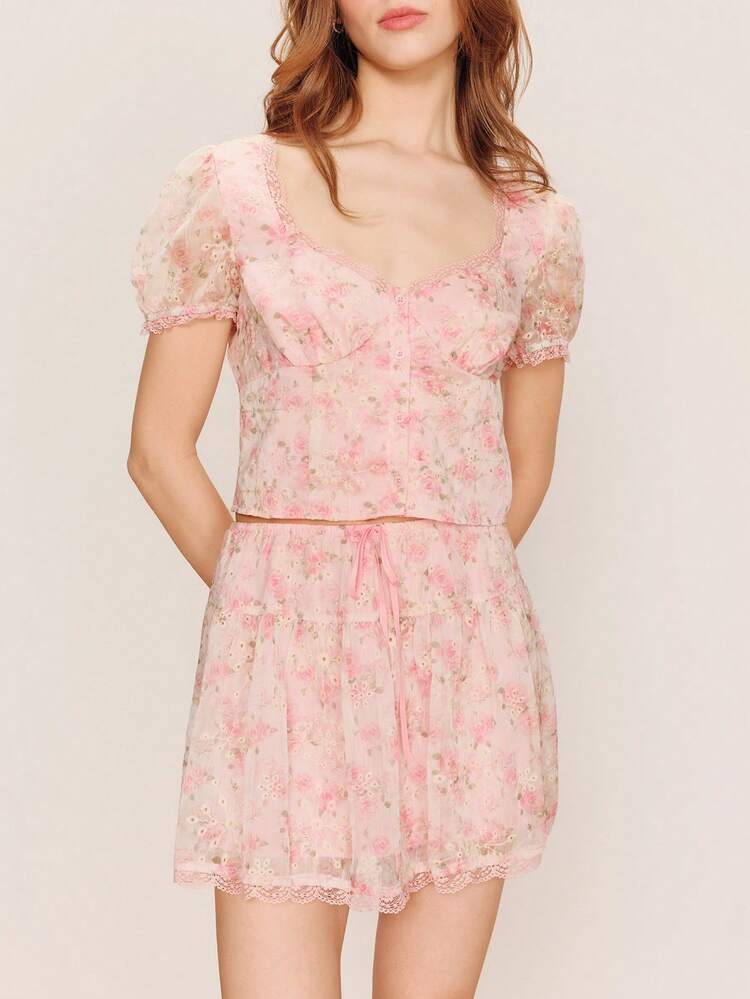 Romantisches rosa Set mit Lochstickerei, bestehend aus Oberteil mit Puffärmeln und passendem Rock. Niedliches zweiteiliges Blumenset mit rosa Blumenoberteil und Shorts. Französischer Frühlings-/Sommerstil im Pariser Stil.
