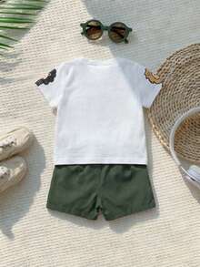 SHEIN Playful Pals 2件套幼儿男童可爱动物印花圆领短袖T恤和松紧腰短裤套装，白色T恤印有长颈鹿、斑马和狮子图案，搭配纯绿色短裤，可爱户外/休闲/运动套装，适合春夏季节，尺码6个月至3岁 - 軍綠色 - 查看 2