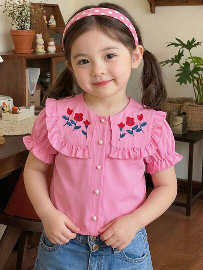 Souflis Souflis Camisa de manga corta con cuello y botones con forma de seta para niños en color fucsia, con gran cuello, ribete de volantes en el cuello y los puños para un aspecto dulce. Bordado floral rojo con acentos de hojas verdes en la parte delantera, añadiendo un encanto juguetón. Botones de seta blanca en la cartera, sencillo pero práctico. Estilo adorable y juguetón adecuado para el uso diario de niñas pequeñas.