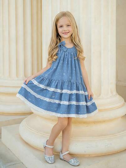 少女甜美田园风无袖连衣裙，蓝色底白色波点蝴蝶结印花，蝴蝶结肩带，层叠荷叶边下摆，蕾丝饰边，A字廓形，面料柔软舒适，时尚日常穿着