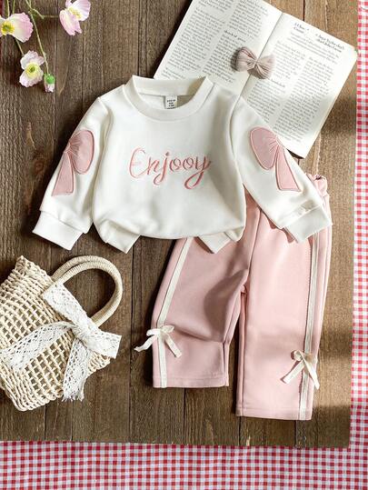 SHEIN Conjunto de niña pequeña con suéter de manga larga con decoración de lazo dulce y pantalones de punto rosa, con diseño de lazo lindo, estilo ajustado adecuado para salidas, uso casual y fiestas