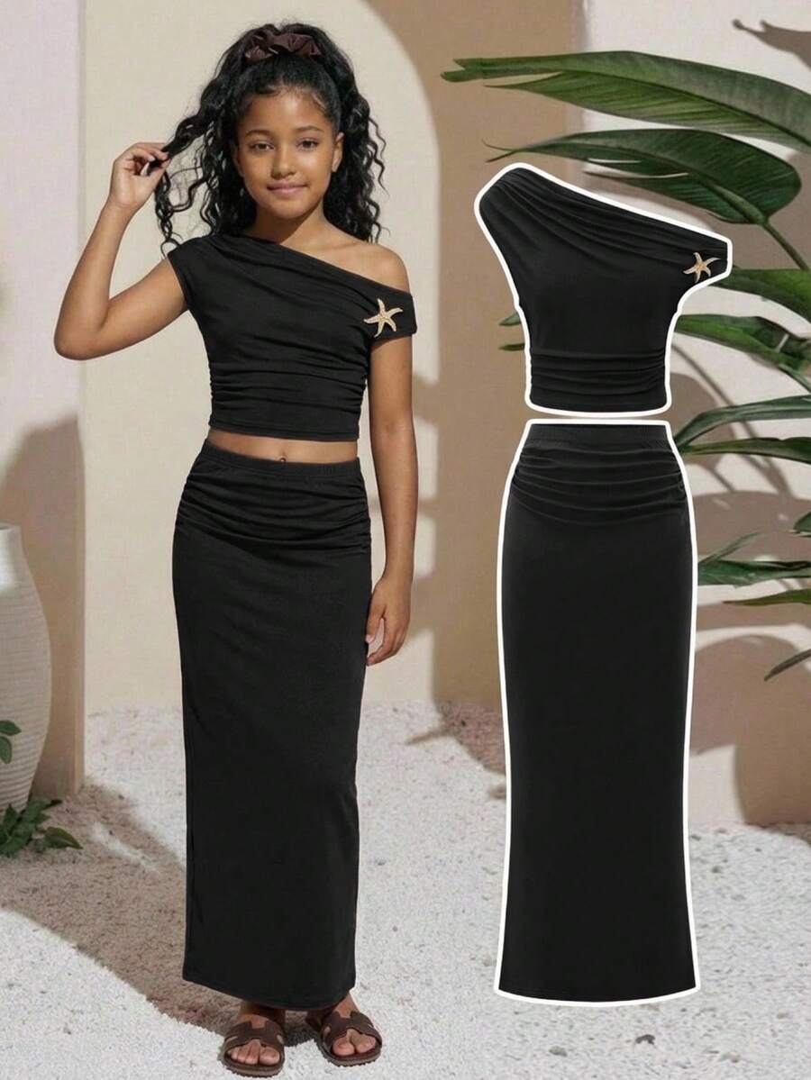 SHEIN Đầm dài màu đen ôm sát cổ bất đối xứng cho bé gái tuổi teen, chất liệu co giãn và mềm mại, thiết kế xếp ly cổ bất đối xứng với họa tiết sao biển vàng, chất liệu mềm mại phù hợp cho nhiều mùa, kiểu dáng xếp ly, trang trí thanh lịch phù hợp cho các dịp bán trang trọng/xã hội, duyên dáng, không bó sát và dễ phối đồ, tạo nên vẻ ngoài dịu dàng và trẻ trung. - màu đen - Xem 1