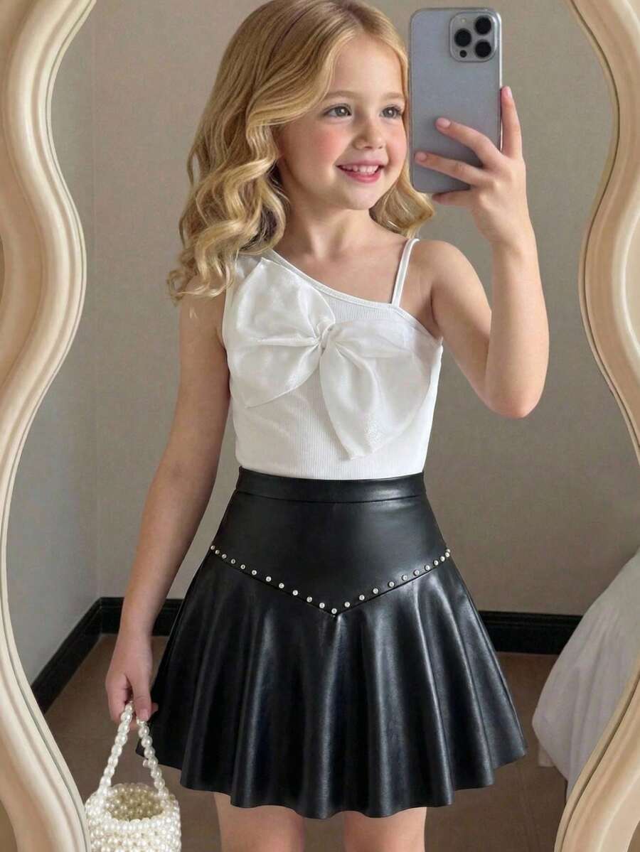 Elladie kids Conjunto de 2 piezas dulce y fresco para niñas preadolescentes, top de un hombro con lazo a juego con minifalda de cuero PU con tachuelas, ajustado y favorecedor, que irradia un ambiente dulce y caliente de chica, adecuado para salidas casuales, fiestas o uso escolar, fácil de crear looks personalizados - Blanco y Negro - Ver 1