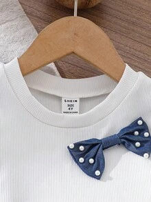 Elladie kids 春夏新款女童休闲时尚上衣套装。正面采用白色针织珠饰设计，蓝色亚麻混纺面料，饰有3D蝴蝶结。白色罗纹针织面料，饰有刺绣花卉边饰。无袖圆领上衣搭配白色珠饰蓝色牛仔裤，两件套。可爱韩版风格，适合春夏日常穿着、上学、外出、度假、聚会和节日等场合。适合女童牛仔套装、珍珠元素、女童服装套装、夏季服装。 - 藍色 - 查看 8