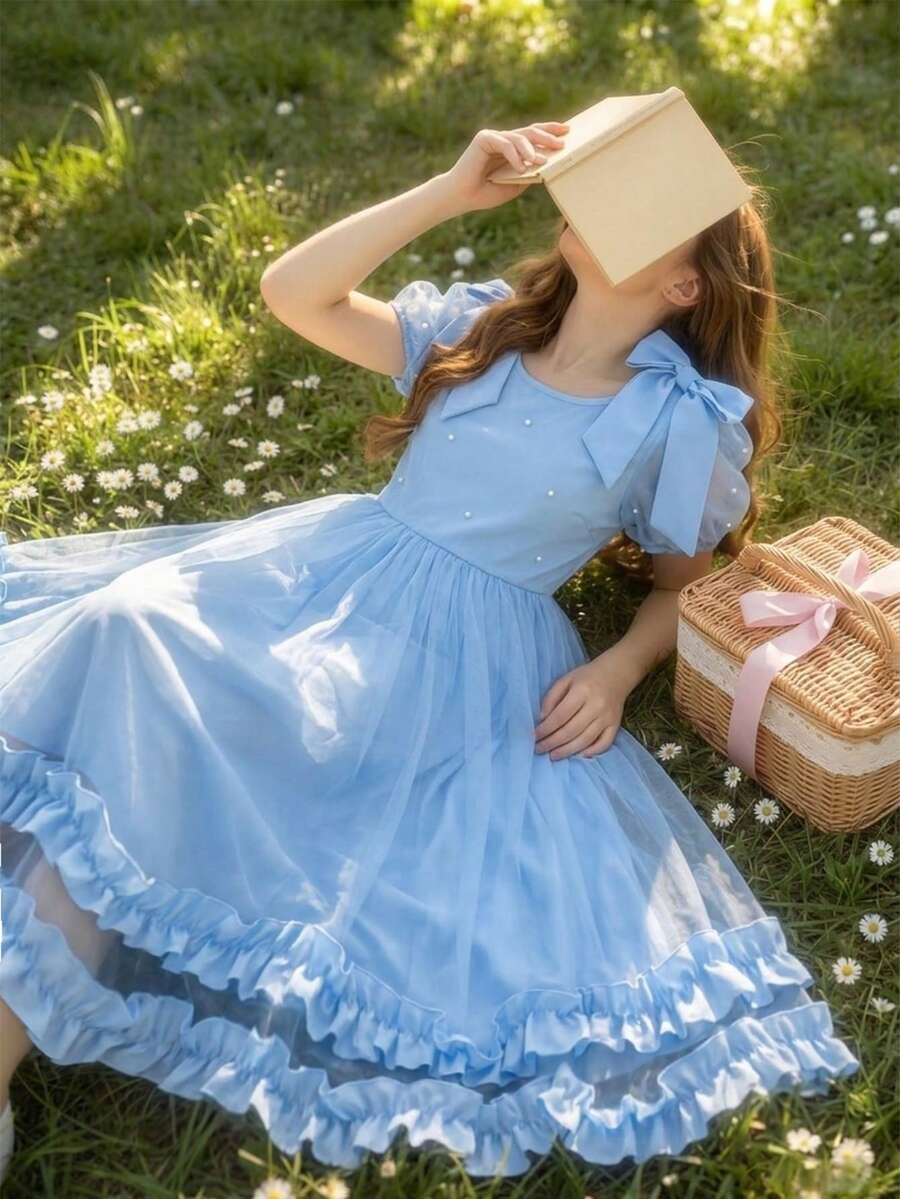 SHEIN 少女蓝色优雅连衣裙。这款公主风连衣裙适合儿童日常穿着、生日派对、钢琴演奏会、婚礼花童等各种场合。连衣裙采用蓝色雪纺面料，肩部饰有大蝴蝶结。