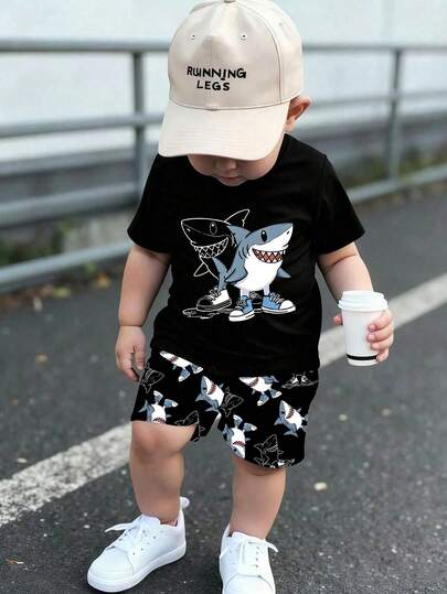 Set de 2 piezas Camiseta de manga corta con cuello redondo estampada con tiburón usando zapatos emparejada con pantalones cortos estampados con tiburón para niños, estilo casual y de moda, patrón divertido, adecuado para deportes al aire libre en verano, conjunto de camiseta de manga corta suave y cómoda + pantalones cortos, excelente para el uso de los niños, actividades al aire libre