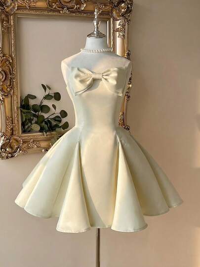 Lovelzi Elegant, Glamorous, And Stylish Light Yellow Satin Dress With A Large Handmade Bow Embellishment. Strapless Bodice With Triangular Embellishments, A-Line Silhouette, Short Length. Suitable For Parties, Dates, Birthday Parties, Wedding Receptions, Cocktail Parties, And Prom Dresses.
