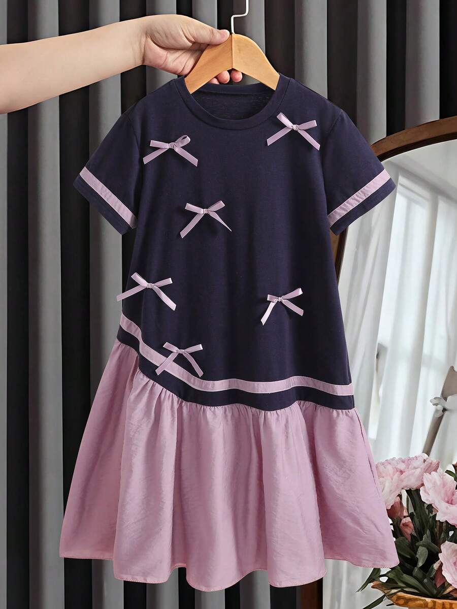 SHEIN 少女夏季休闲中长连衣裙 - 藏蓝色针织面料拼接浅粉色梭织面料,饰以多个粉色蝴蝶结,尽显精致活泼。撞色袖子和下摆营造出层次感,适合周末、家庭出游或休闲上学日穿着。 - 彩色 - 查看 1
