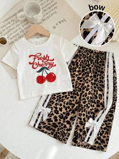 SHEIN Conjunto de 2 piezas para bebé niña con blusa de cuello redondo blanca con estampado de cerezas lindo y pantalones con estampado de leopardo con decoración de moño