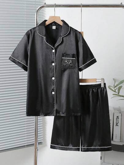Bộ đồ ngủ 2 món cho bé trai tuổi teen, in chữ và hình đồ họa, chất liệu poplin màu xanh dương, tay ngắn và quần short.