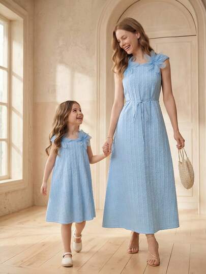 小女孩夏季连衣裙，浅蓝色泡泡面料连衣裙，质地清新柔软，肩部饰有 3D 立体花朵，活泼俏皮，直筒廓形舒适自由，展现童真魅力和温柔治愈力。