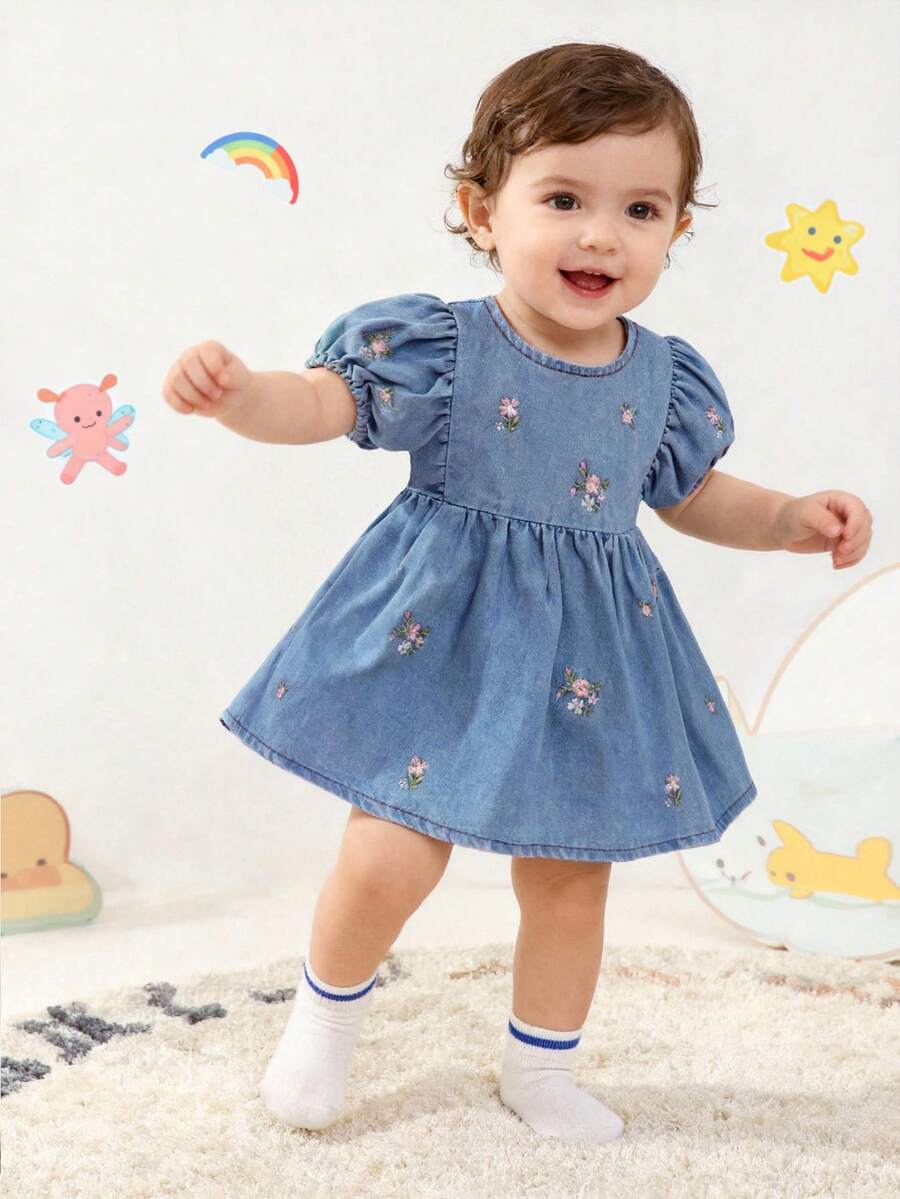 SHEIN Vintaside Kids Đầm denim mùa hè cho bé gái, kiểu dáng dễ thương đồng quê, chất liệu denim màu xanh nhạt với họa tiết thêu hoa nhiều màu sắc, kết hợp với tay phồng và dáng chữ A cạp cao, tạo nên sự kết hợp hoàn hảo giữa vẻ lãng mạn mộc mạc và sự thoải mái khi mặc, giúp bé có một mùa hè đáng yêu trọn vẹn.