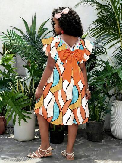 Jurk voor tienermeisjes in oranje en blauw met geometrische print, korte mouwen en strik - Met een levendige oranje, frisse blauwe en pure witte basis is de abstracte geometrische print vol artistieke spanning. De 3D-fladdermouwen zijn levendig en speels, de V-hals aan de achterkant is versierd met kleurrijke kwastjes en de grote oranje strik zorgt voor een nette pasvorm. De elastische tailleband maakt deze jurk geschikt voor de zomer. Met een gepersonaliseerde print, schattige details en een comfortabele pasvorm is dit een modieus kinderjurkje voor dagelijkse uitjes, familievakanties, verjaardagsfeestjes en meer!
