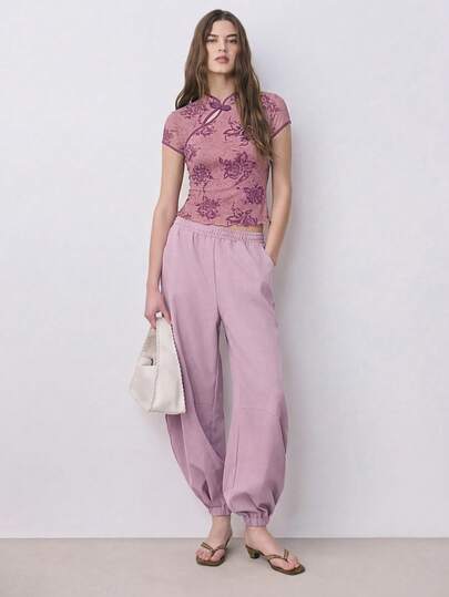 Nöista 这款印花短袖修身上衣采用中式立领设计，搭配打结式盘扣，轻盈柔软的面料和撞色滚边营造出复古东方韵味，是春季穿搭、约会之夜、春季造型、休闲时尚以及日常精致装扮的理想之选。