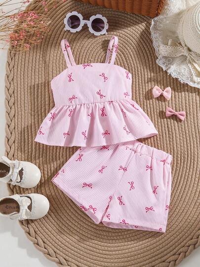SHEIN Vintaside Kids Bebé niña. El conjunto de top halter sin espalda y falda corta a rayas en rosa suave y blanco es un estilo de vacaciones dulce, juguetón y adorable. Está hecho de tela tejida, con una forma que se ajusta bien. Toda la pieza está impresa con lazos pequeños en rosa y patrones a rayas. El dobladillo tiene un borde con volantes que es alegre y elegante. Es adecuado para salidas diarias, ir a la escuela, vacaciones en la playa, asistir a fiestas y eventos, y relajarse en casa.