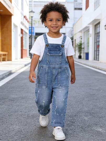 男童牛仔背带裤，夏季新品系列，简约休闲校园风，浅蓝色复古配色，夏季假日新品上市，经典背带设计，标志性的白色泼墨/点状印花是视觉焦点，模拟艺术涂鸦效果，增强街头潮流感；搭配做旧纹理，提升复古层次感。柔软的棉质牛仔面料，穿着舒适，适合夏季度假、户外活动、派对、音乐节等多种场合。