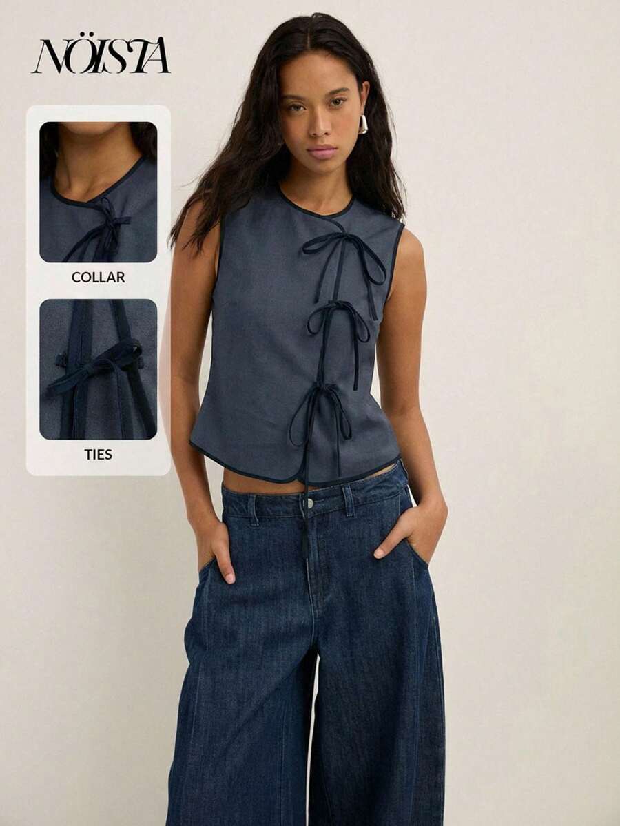 Nöista Áo tank top nữ gân sọc với cổ tròn cổ điển và chi tiết buộc dây phía trước, được thiết kế để tôn dáng và có thể điều chỉnh. Một món đồ đa năng và thoải mái, hoàn hảo cho những buổi đi làm hàng ngày hoặc những bộ trang phục mùa xuân và mùa hè dễ phối. - Màu xanh bụi bặm - Xem 1