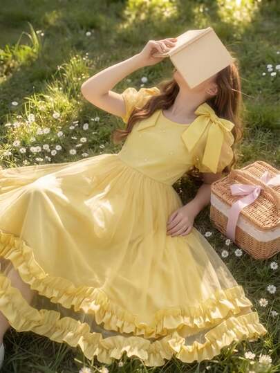 SHEIN Vestido azul elegante para niñas. Este es un vestido estilo princesa con un diseño refinado, adecuado para el uso diario de los niños, fiestas de cumpleaños, recitales de piano, niña de las flores en bodas y otras ocasiones. Está hecho de material de gasa azul, con un gran lazo en el hombro, mangas abullonadas, adornos de perlas por todas partes y una falda con volantes multicapa, que resalta los detalles exquisitos y crea una sensación de cuento de hadas. Esta es una opción popular para ocasiones diarias o formales de los niños.