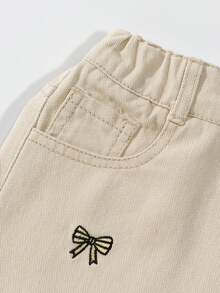 Genkimix Kids Quần jeans ống rộng màu kaki nhạt dành cho bé gái, thiết kế gấu quần thắt nơ, phối cùng họa tiết thêu dâu tây đỏ và nơ vàng, tươi tắn và ngọt ngào, phù hợp cho trang phục thường ngày mùa xuân/hè, có thể phối cùng áo phông hoặc áo sơ mi để tạo phong cách thoải mái và nghệ thuật, ôm sát và giúp tôn dáng, lý tưởng cho các buổi đi chơi và mua sắm. - Rửa nhẹ - Xem 4