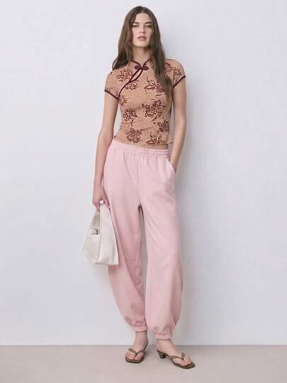 Nöista 这款印花短袖修身上衣采用中式立领设计，搭配打结式盘扣，轻盈柔软的面料和撞色滚边营造出复古东方韵味，是春季穿搭、约会之夜、春季造型、休闲时尚以及日常精致装扮的理想之选。